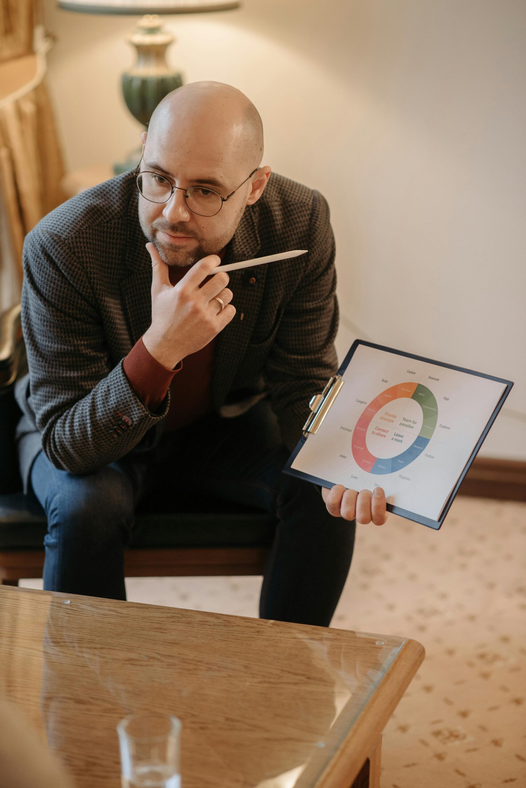 A serious counselor discusses mental health using a chart on a clipboard.