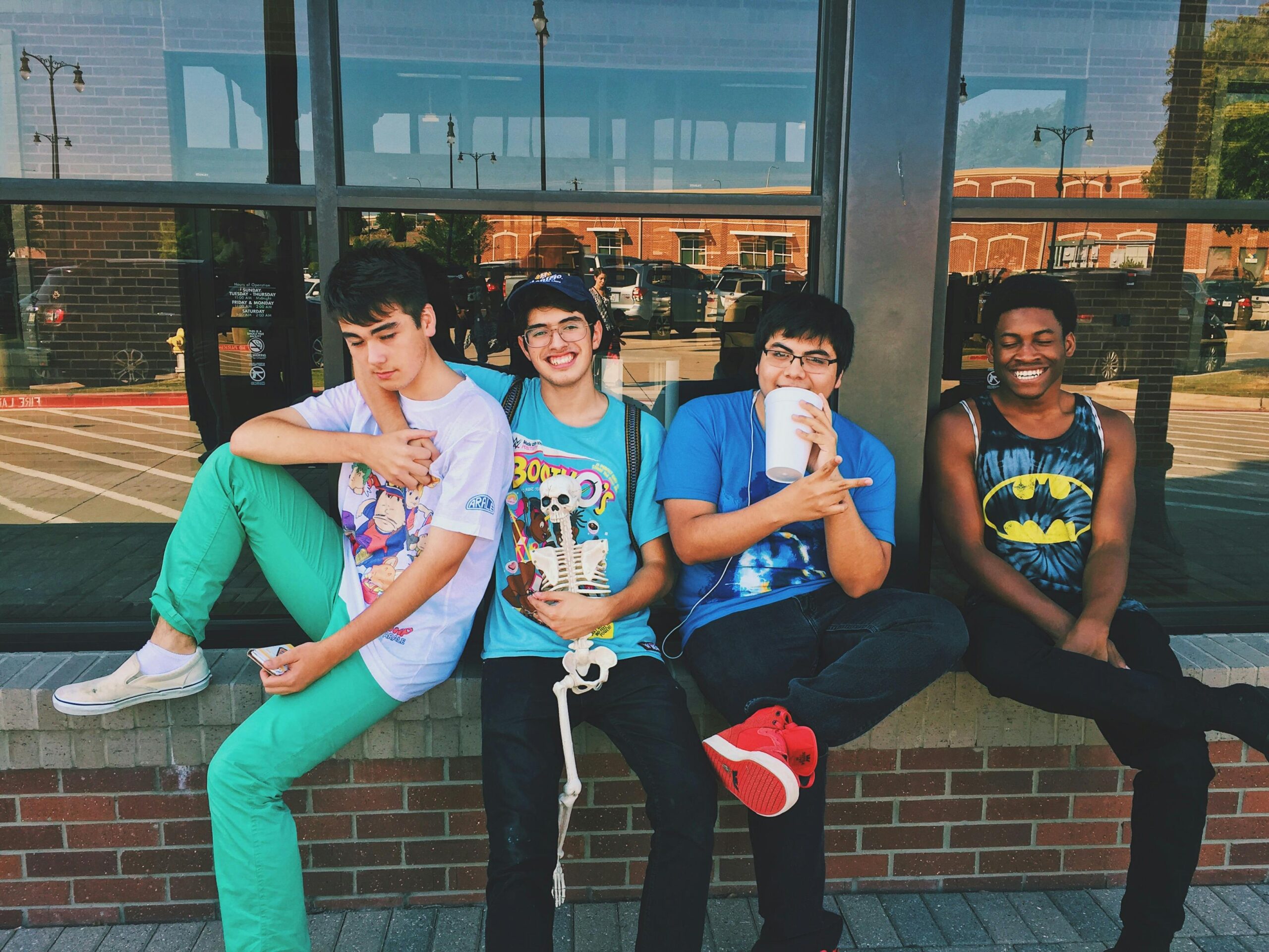 Group of teenage friends sitting outdoors, smiling and having fun together.