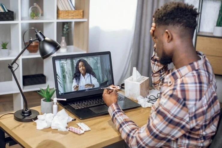 Man consulting with a doctor during a telepsychiatry session via laptop in Long Beach