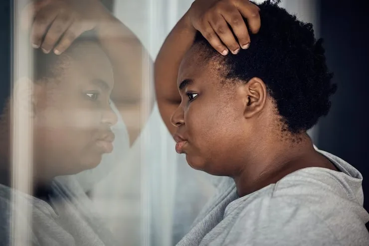 Person looking at window reflection experiencing bipolar disorder mood changes at Mentally Healthy Care in Long Beach, CA.