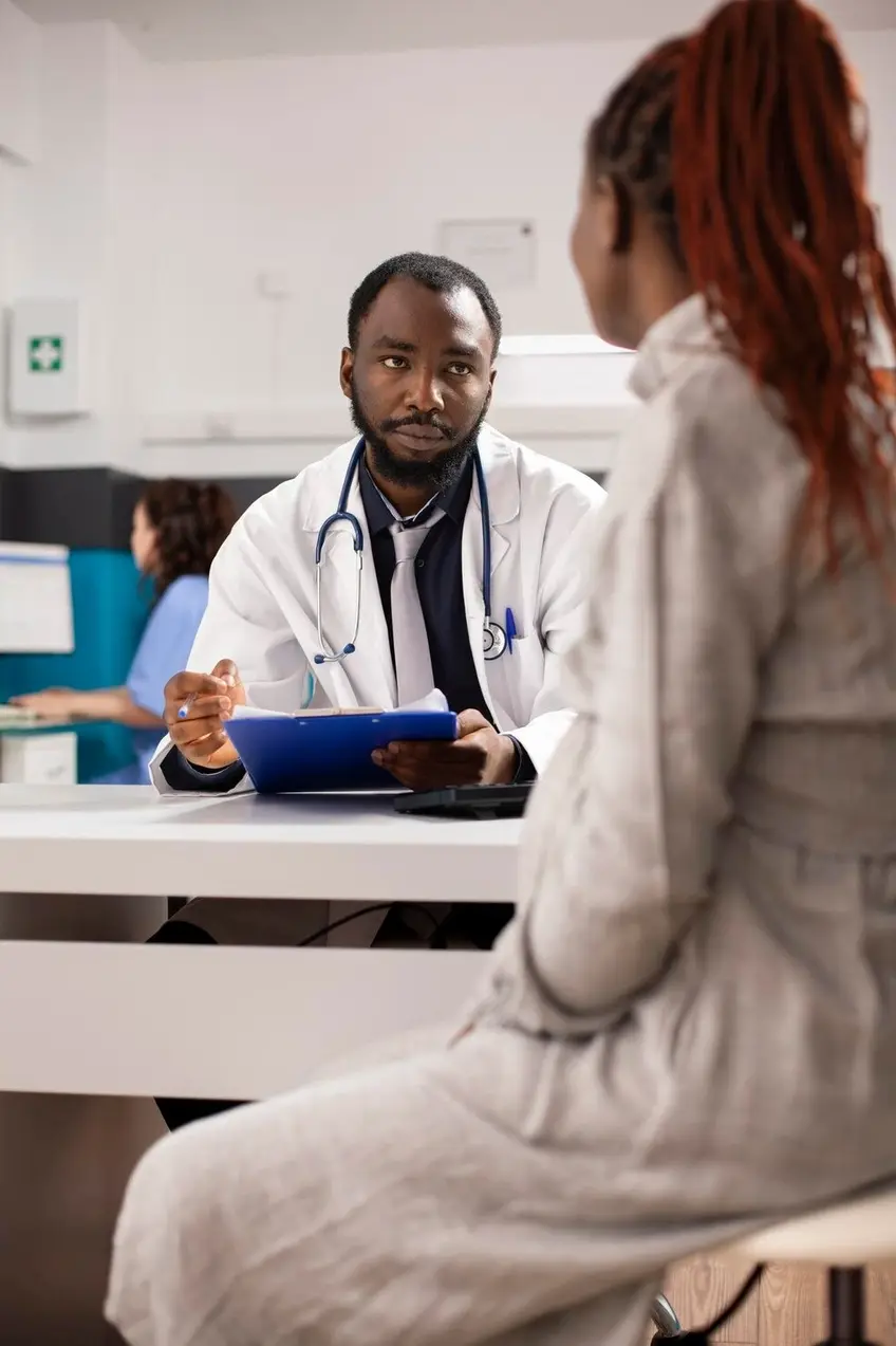 Psychiatrist holding clipboard while listening to a patient during a consultation at Mentally Healthy Care