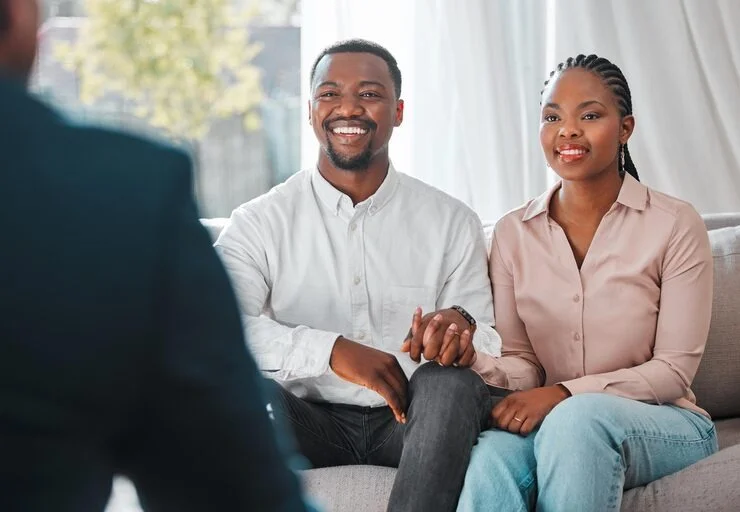 Smiling husband and wife speaking with a licensed therapist at Mentally Healthy Care