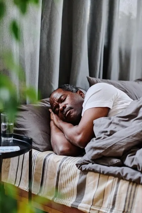 Senior man trying to sleep while managing sleep disorder symptoms at Mentally Healthy Care in Long Beach, CA