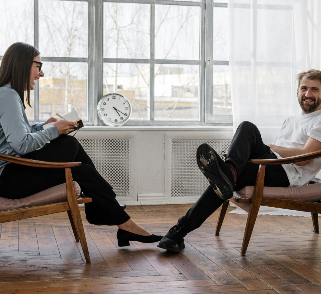 Counselor and client in a positive therapy session in a well-lit room.